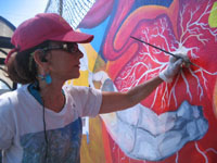 Miranda Bergman painting a mural.